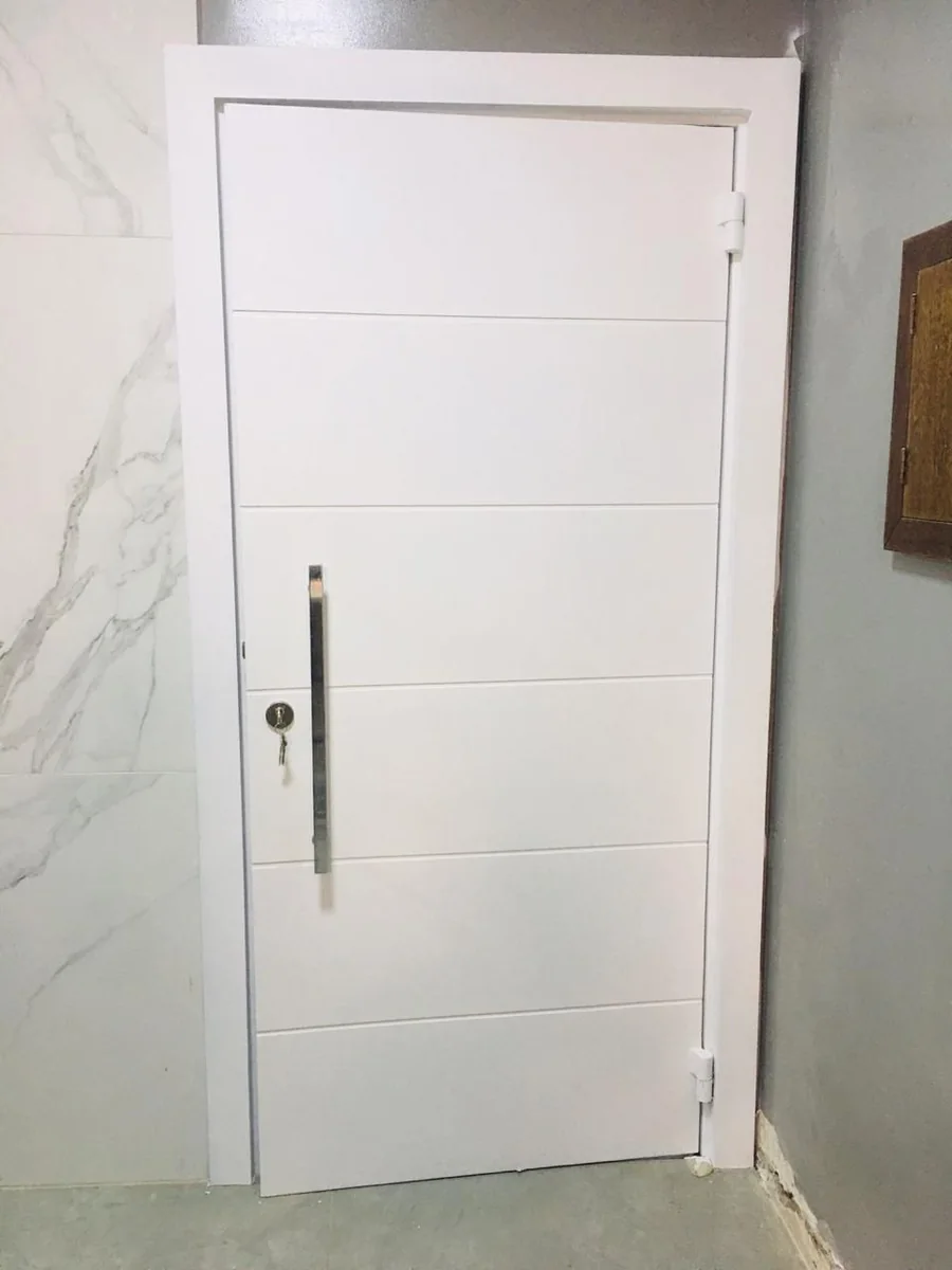 Porta branca com frisos horizontais instalada em parede de revestimento claro; projeto real do grupo.