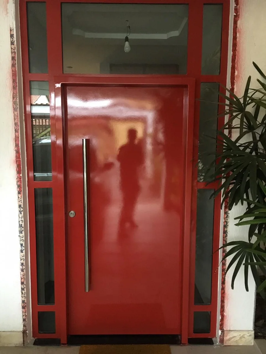 Porta vermelha com puxador vertical e vidros laterais; projeto real do grupo.